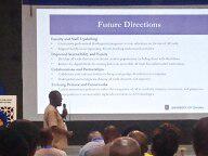 A person standing in front of a large screenDescription automatically generated